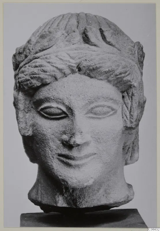 Limestone head of a figure from Mersinaki, shown on a dark stand