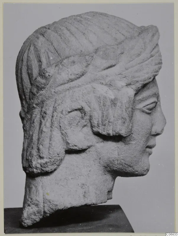 Limestone head and bust from Mersinaki, shown in profile facing right on a dark stand