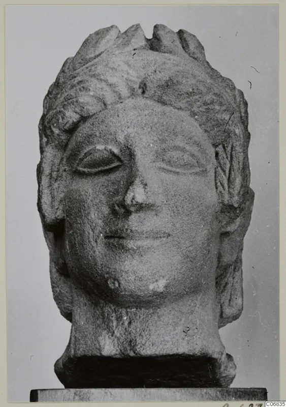 Limestone head of a figure from Mersinaki, with wavy hair and a slight smile, shown frontally