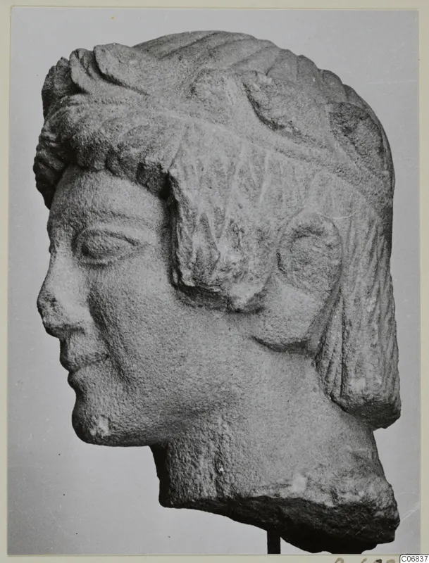 Limestone bust from Mersinaki, shown in profile facing left, with a ridged hairstyle and a broken base.