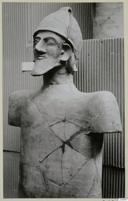 Terracotta statue of a helmeted figure, upper body, with cracks and repairs across the chest and neck