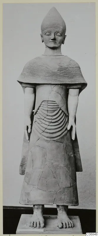 Terracotta statue of a standing figure with a pointed headdress and incised cape, from Ayia Irini