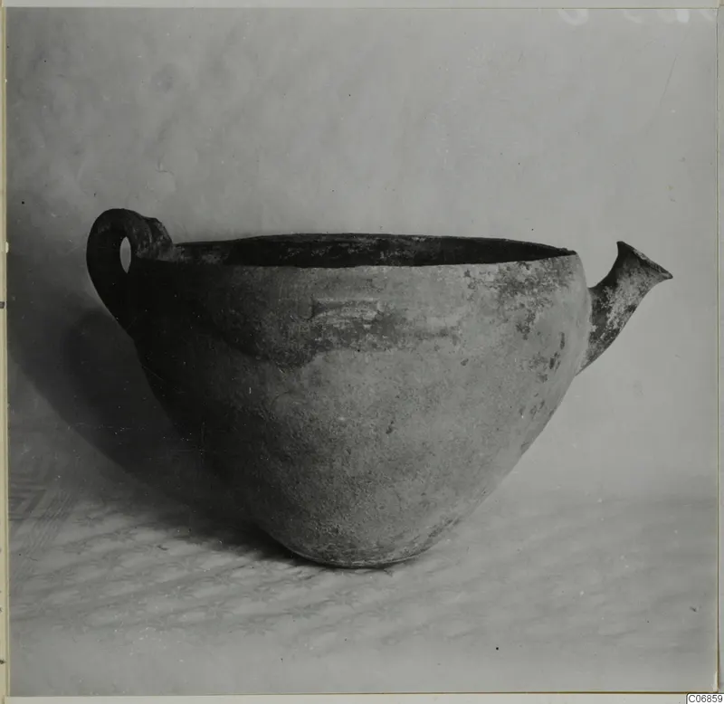Pottery Red Polished III bowl with a loop handle on the left and a short spout on the right, shown from the side