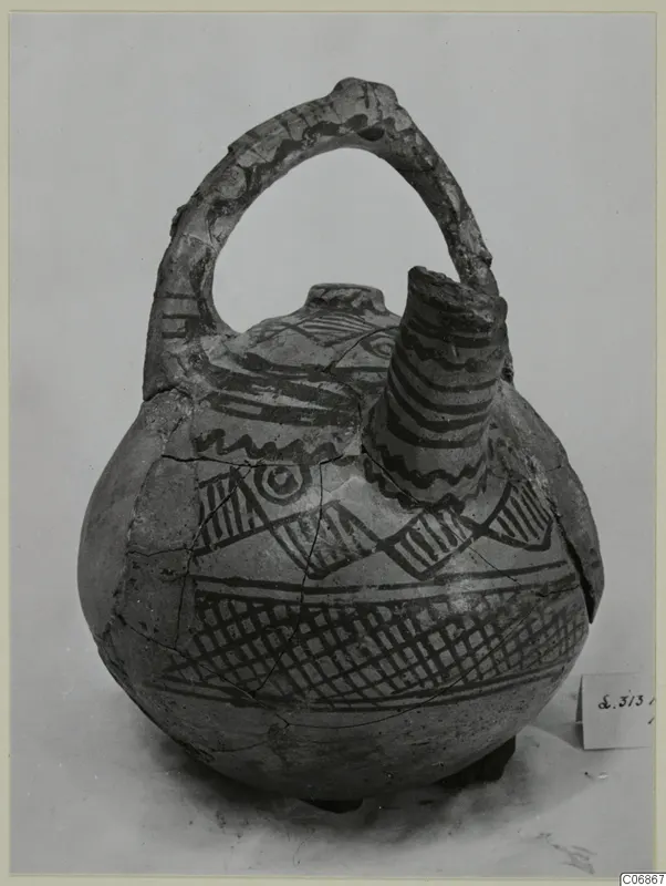Painted pottery jug with a strap handle and tall spout, decorated with dark bands, zigzags and cross-hatching