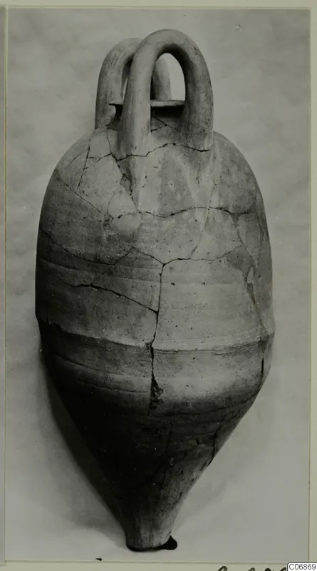 Pottery vessel with two loop handles and a pointed base, cracked and joined, against a pale background