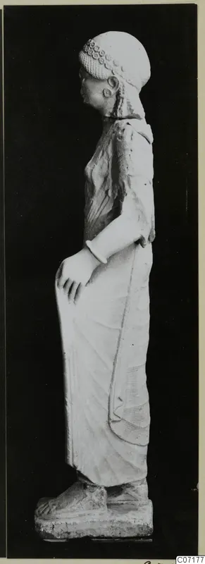 Limestone statue of a standing woman from Vouni, shown in profile against a black background