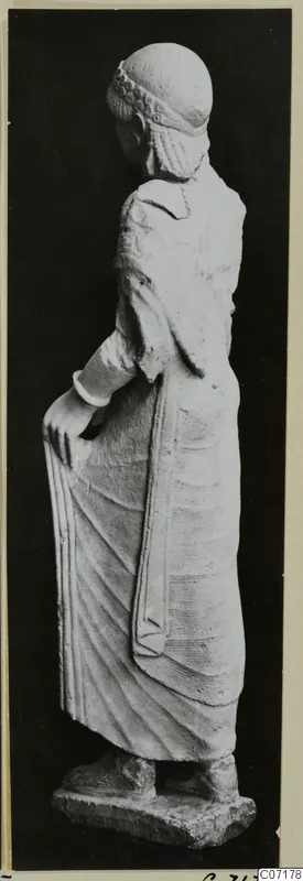 Limestone statue of a standing woman from Vouni, shown from the side and slightly from behind
