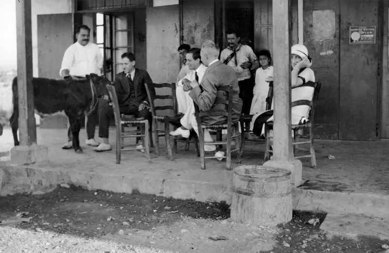 Café veranda in Karavostasi with Einar Gjerstad and John and Rosa Lindros, seated beside an animal