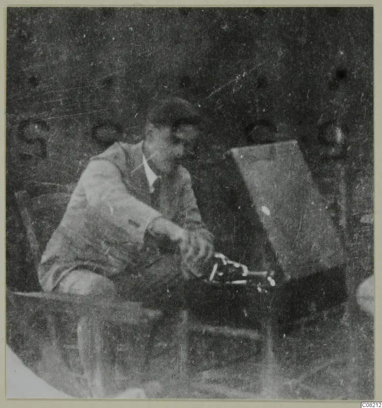Man seated beside a dark box-like object with metal fittings at Machairas, possibly Einar Gjerstad
