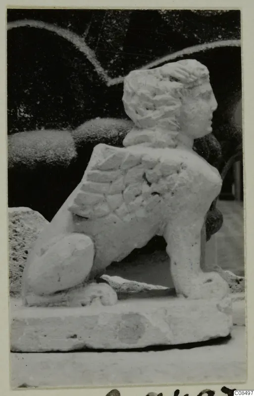 Carved white stone statue of a winged creature with a human head and lion-like body, from Soli