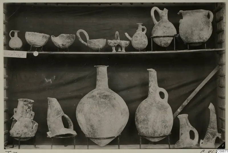 Pottery jars and bowls from T.7 at Lapithos Markides, set out on two shelves.