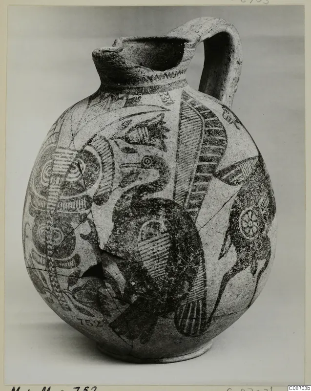 Pottery Bichrome IV jug with a strap handle, painted with a large bird and geometric patterns, shown against a grey backdrop.