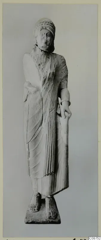 Limestone statue of a standing woman from Vouni, holding a tall rod, on a rectangular base