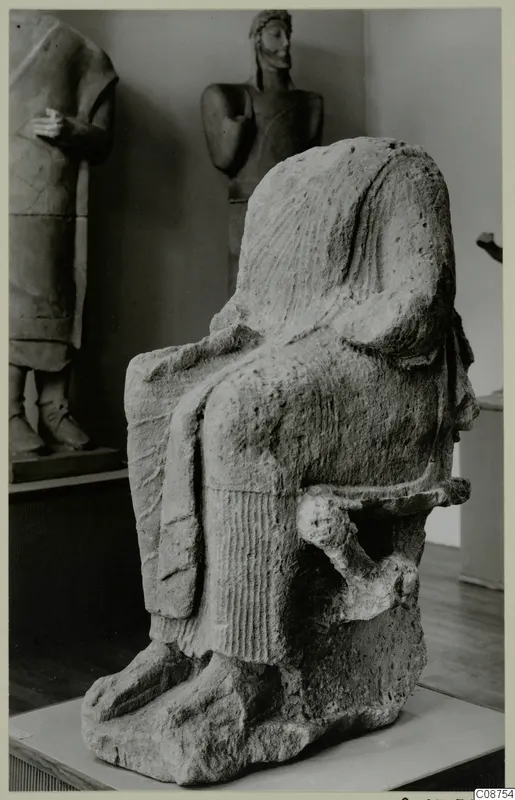Neo-Cypriote limestone statue of a seated figure in a chair, photographed in a museum gallery