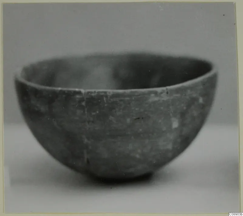 Pottery Red Polished III bowl, photographed from the side on a pale surface.