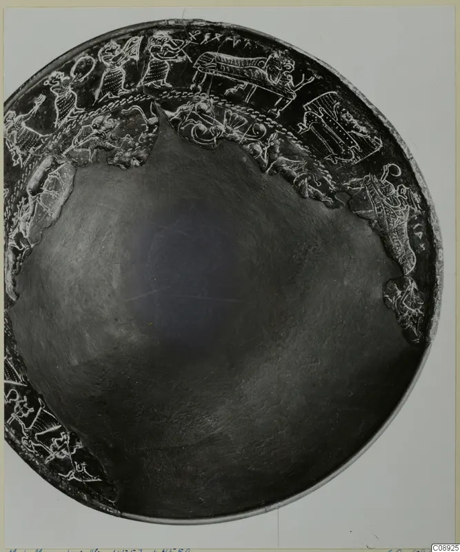Dark bowl viewed from above, with a band of raised figures and animals in relief around its rim.