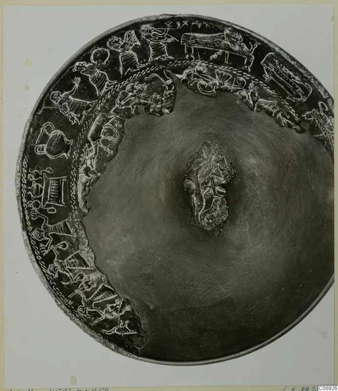Decorated metal bowl seen from above, with a frieze of figures and animals around the rim