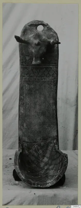 Pottery White Painted III-1: tall pottery object with a modelled animal head near the top and a trough-shaped base.