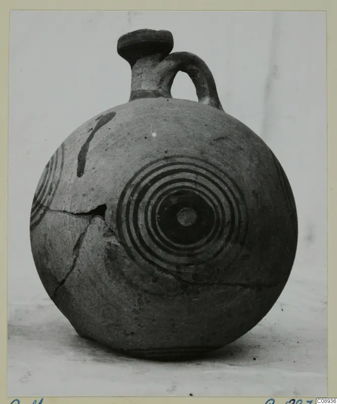 Round jug with a single loop handle and concentric circles painted on its body, shown against a plain background.