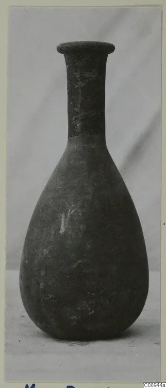 Pottery bottle with a long narrow neck, flared rim and pear-shaped body, photographed upright.