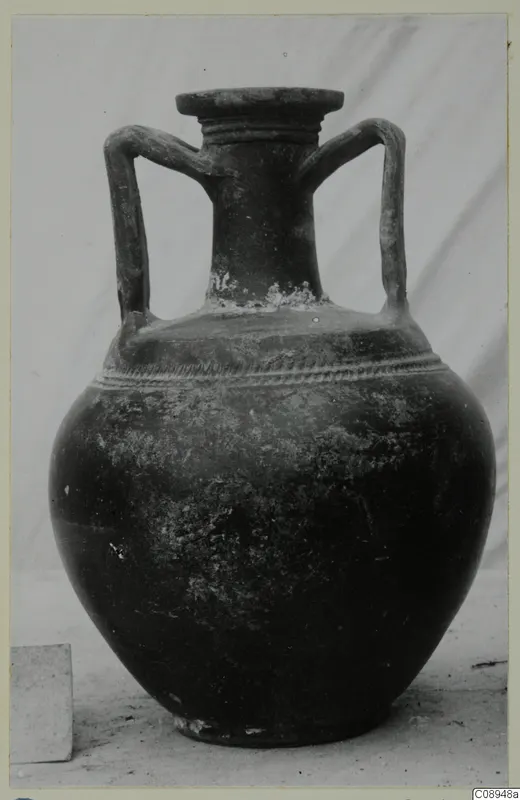 Two-handled dark pottery jar with a flared rim and a ridged band around the shoulder.