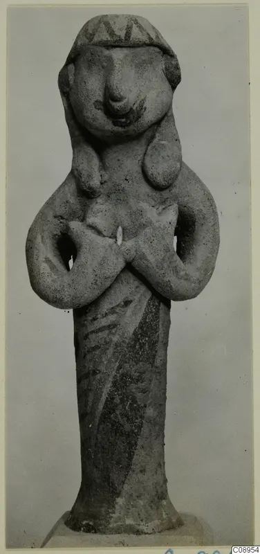 Terracotta figurine of a standing figure with arms crossed at the chest, with a patterned headdress band