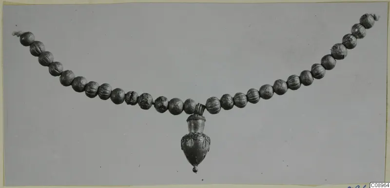 Necklace of ribbed beads with a vessel-shaped pendant hanging from the centre
