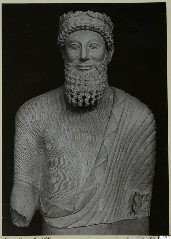 Carved limestone bust of a bearded man with a leafy wreath, from Arsos VII in the British Museum
