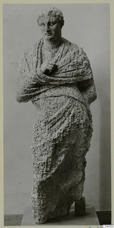 Standing draped statue in pale, porous stone, from Mersinaki