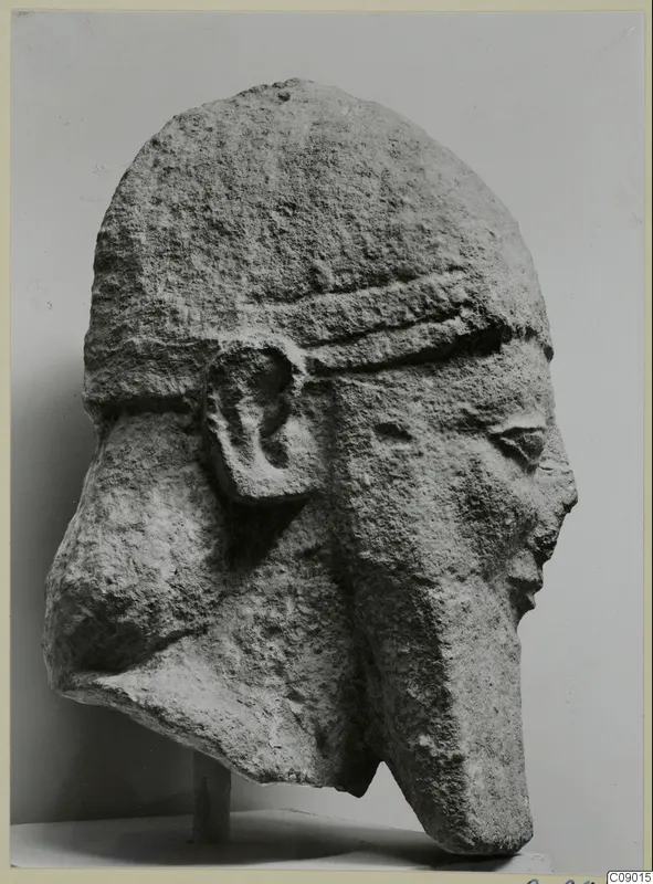 Limestone head from Kition, seen in profile, with a close-fitting cap, a large ear and a worn nose