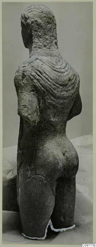 Back view of a limestone statue of a standing man from Mersinaki