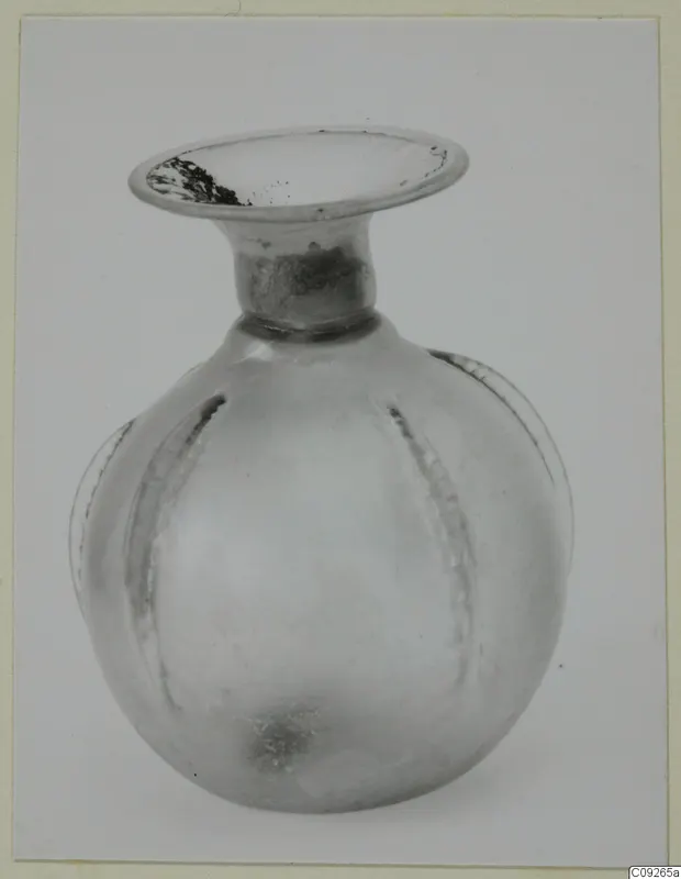 Blown glass unguentarium with a flaring rim and a ribbed, rounded body