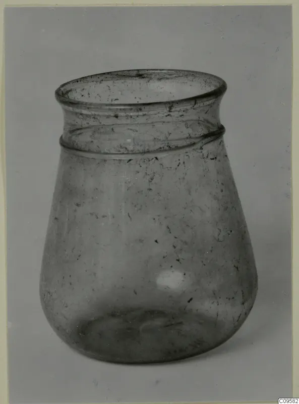 Blown glass jar with a flared rim and a ridged band below it, shown against a grey backdrop.