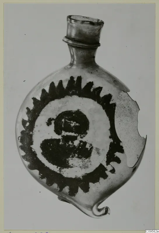 Blown glass flask with a dark sawtooth-rimmed roundel painted on its body