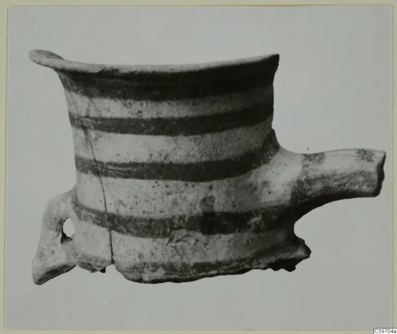 Pottery vessel with a flared rim, horizontal dark bands, a loop handle on the left and a tubular spout on the right