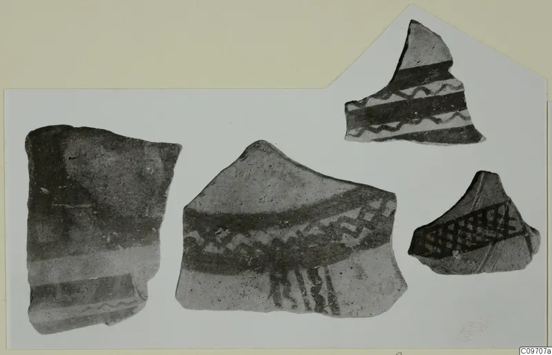 Four pottery sherds with dark painted bands, wavy lines and cross-hatching, shown together on a card
