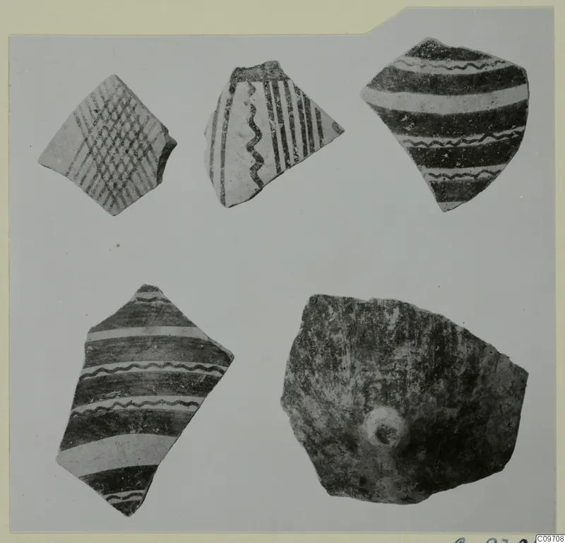 Five pottery sherds with painted bands, wavy lines and crosshatching, laid out on a grey background.