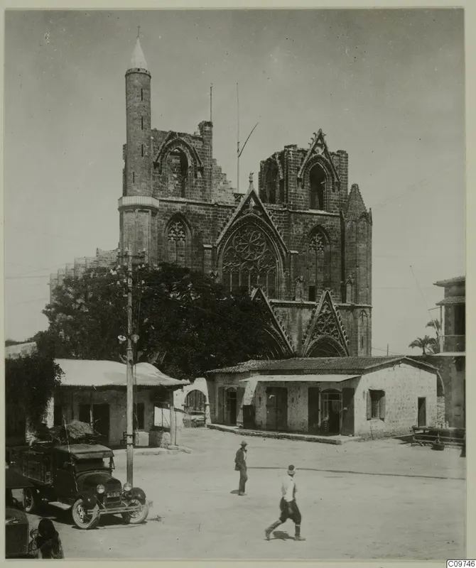 Stone façade of the Lala Mustafa Pasha Mosque, Famagusta, with a slender minaret, seen across an open square