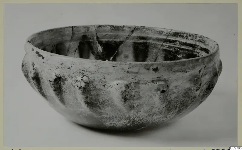 Rounded bowl with a thick rim and grooved lower body, shown on a plain grey background