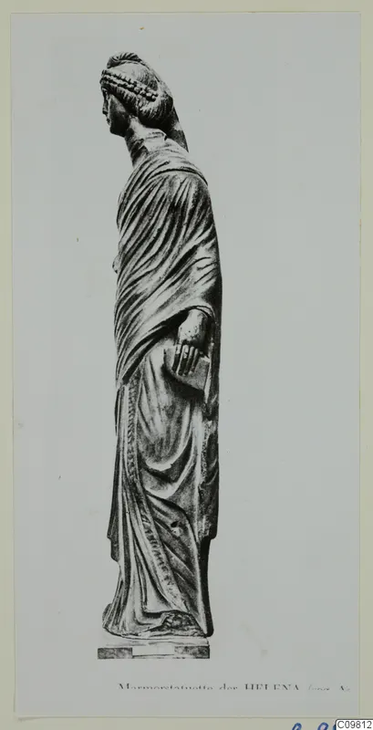Mounted photograph of a standing stone statue of a draped female figure, seen in profile with the head turned left.