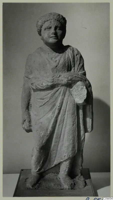 Standing limestone statue of a draped figure from Mersinaki, photographed against a grey backdrop