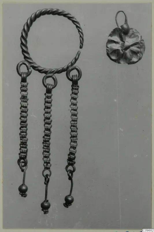 Earring with a twisted wire hoop, three beaded chains ending in small balls, and a disc pendant with loop.
