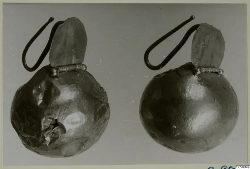 Two gold-coloured earrings with round hollow bodies, hooked wires and leaf-shaped pendants.