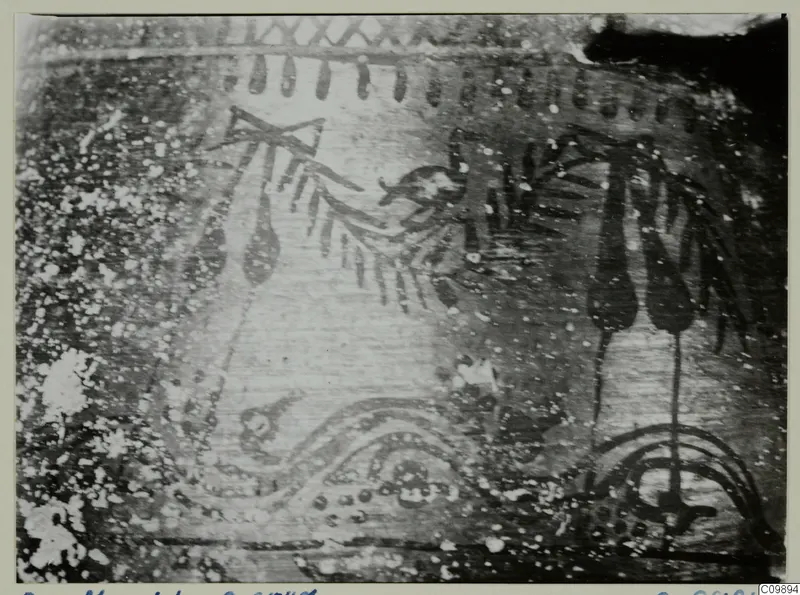Close photograph of a painted find surface with dark motifs of sprays, drops and arcs, and a possible bird-like figure