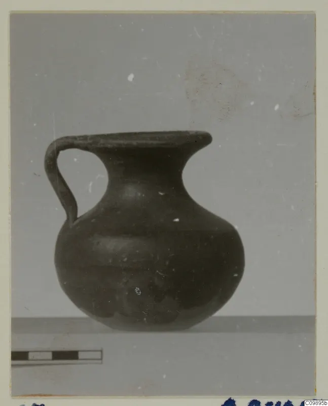Dark one-handled jug with a round body and flaring mouth, from tombs at Ajii Omologitades, Politiko and Limassol Oasis