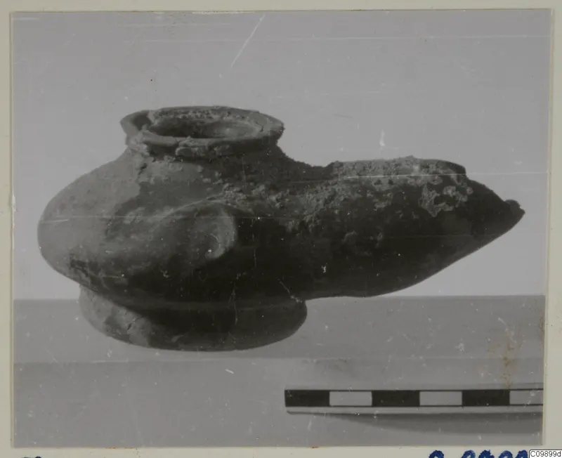 Pottery vessel with a wide top opening, a long pointed spout and a ring base, shown beside a scale bar