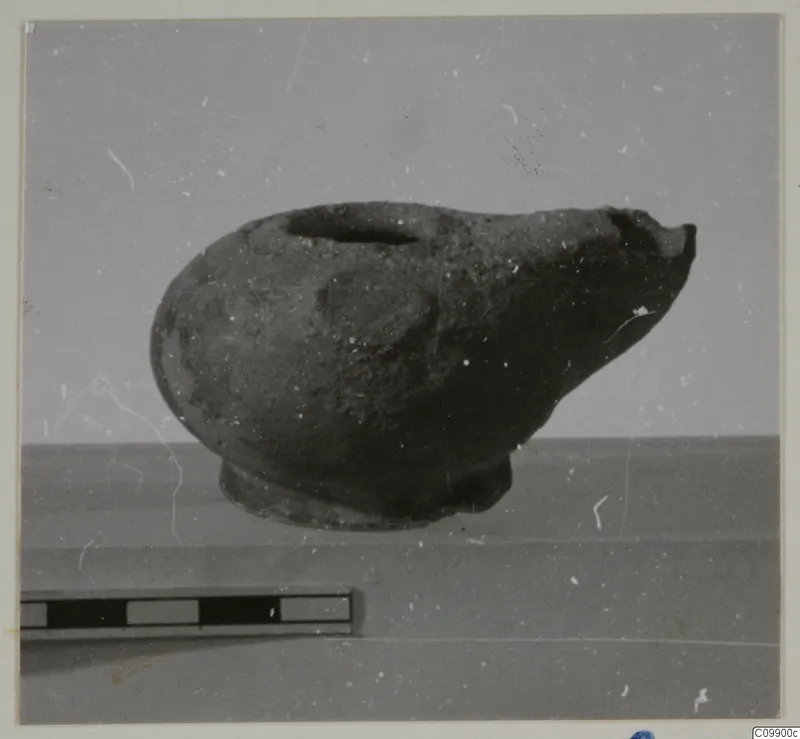 Pottery vessel with a filling hole and broken spout, shown beside a scale bar