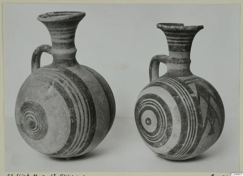 Two White Painted I jugs with banded and concentric circle decoration, shown side by side.