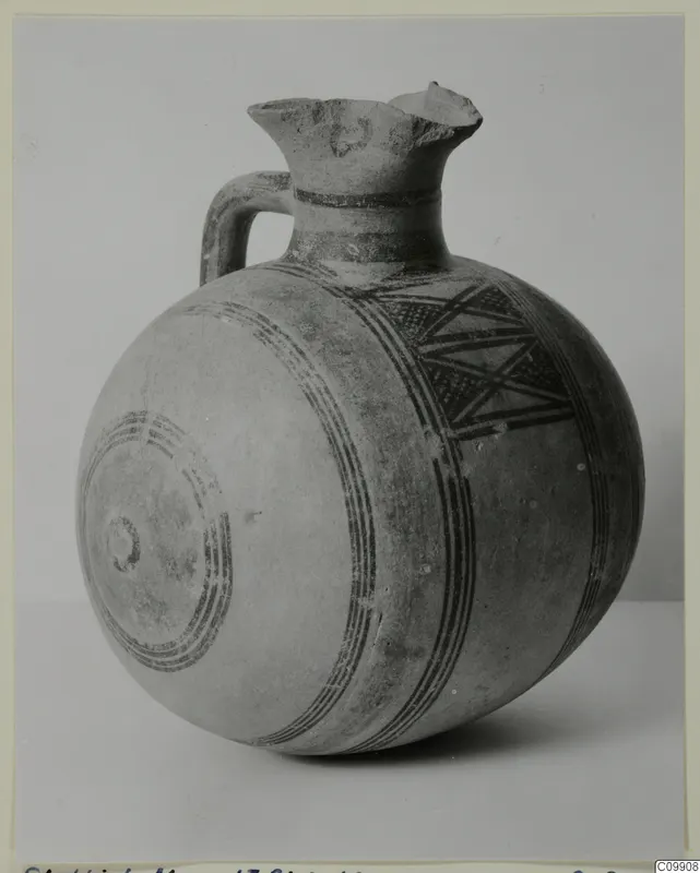 Pottery Bichrome II jug with a rounded body, flared neck, strap handle and dark painted bands