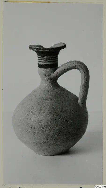 Juglet with a single loop handle, a flaring rim and bands of paint on the neck.